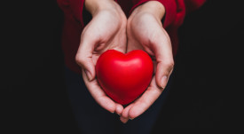 hands-holding-heart-dark-background